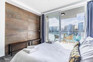 een slaapkamer met een bed en een groot raam bij Spinola Studio Deluxe, StJulians in St Julian's