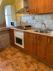 a kitchen with a sink and a stove at Casa Olmos in Iznatoraf