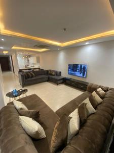 a large living room with a couch and a tv at AirReside Hotel Apartments Gold Crest in Lahore