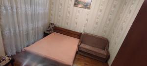 Habitación pequeña con cama y cortina en Holiday Home u Tetiany, en Kamianets-Podilskyi
