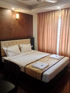 a bedroom with a large bed with towels on it at Hotel Samudyatha Inn And Suites in Kundapur