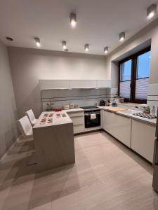 a large kitchen with white cabinets and a table at APARTAMENTY NOWE CENTRUM 2 in Łódź