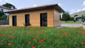 un pequeño edificio en un campo de flores en Le Spa du Verger de Firmin - jacuzzi intérieur privé en Foix