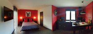 1 dormitorio con paredes rojas, 1 cama y escritorio en Le Spa du Verger de Firmin - jacuzzi intérieur privé en Foix