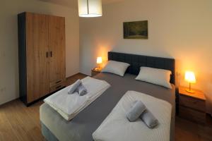 a bedroom with two beds and two lamps in it at Holiday Baranja in Kopačevo +25 photos