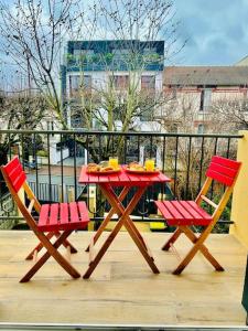 una mesa roja y 2 sillas en el balcón en An Exceptional Apartment, 20 Min Paris, 10 Min Orly Airport, 30 Min Disney, 25 Min Versailles, Parking free, en Antony