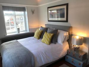 a bedroom with a white bed with pillows and a window at CASTLE COTTAGE 2 in Richmond