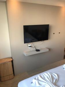 TV de pantalla plana colgada en la pared en Flat apart-hotel pelinca en Campos dos Goytacazes