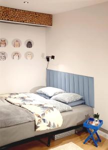 a bedroom with a bed with a blue headboard at miniSowa in Jedlina-Zdrój