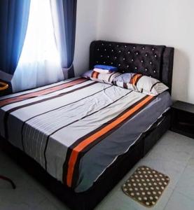a bed sitting in a room with a window at Homestay Cikgu Alif in Wakaf Baharu