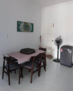a room with a table with chairs and a blender at Homestay Cikgu Alif in Wakaf Baharu