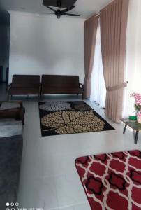 a living room with a couch and a rug at Homestay Cikgu Alif in Wakaf Baharu