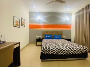 - une chambre avec un lit et 2 oreillers bleus dans l'établissement YS Residence- Alpina, à Gurgaon