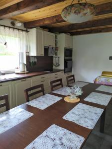 a kitchen with a wooden table with chairs and a dining room at Beba in Heřmanovice