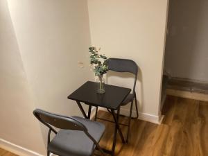 a table with two chairs and a vase with flowers on it at Barn 5 in Vigo Village