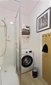 a bathroom with a washing machine and a shower at miniSowa in Jedlina-Zdrój