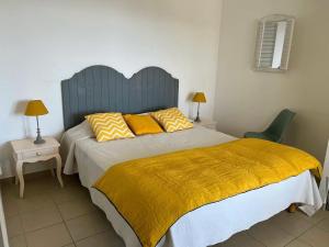 a bedroom with a large bed with a yellow blanket at Residence Castugna in Cargèse