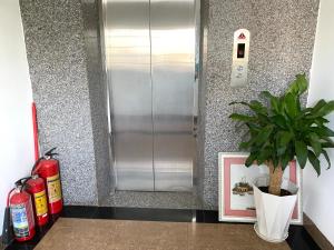 a metal elevator with a potted plant and a picture at Khách sạn Ngọc Hồi 2 in Buôn Kô Sir