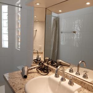 a bathroom with a sink and a large mirror at Próximo shopping Beira Mar in Florianópolis