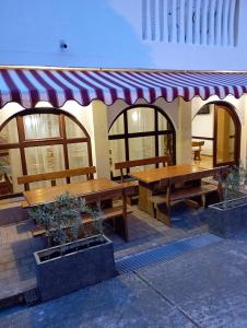 a picnic shelter with benches and a awning at Apartments and pansion M&R in Turanj