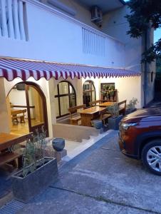 a car parked in front of a house with an awning at Apartments and pansion M&R in Turanj