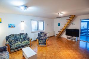 ein Wohnzimmer mit 2 Stühlen und einem Flachbild-TV in der Unterkunft Country House & Spa in Mislinja