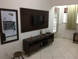 ein Wohnzimmer mit einem TV an der Wand in der Unterkunft Casa para temporada e hospedagem in Juiz de Fora