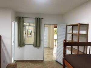 1 dormitorio con litera y puerta con cortinas en Casa para temporada e hospedagem, en Juiz de Fora 55 fotos más