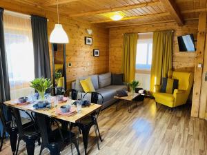 a living room with a table and a couch at Osada Górski Potok in Szczawina