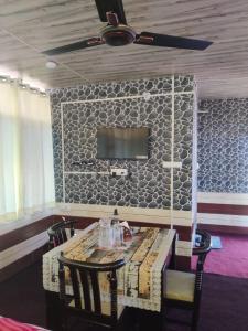 a dining room with a table and a ceiling fan at Gulab - B Homestay in Dehradun