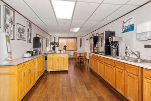 duża kuchnia z drewnianymi szafkami i urządzeniami w obiekcie Super 8 by Wyndham Superior WI w mieście Superior