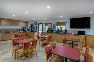 a restaurant with tables and chairs and a kitchen at Travelodge by Wyndham Florida City/Homestead/Everglades in Florida City