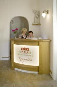 a man and a woman standing behind a counter at Gästehaus "Unsere Stadtvilla" in Hechingen