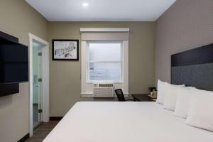 a bedroom with a large white bed and a window at Super 8 by Wyndham San Francisco/Union Square Area in San Francisco