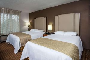ein Hotelzimmer mit 2 Betten und einem Fenster in der Unterkunft Travelodge by Wyndham Fort Wayne North in Fort Wayne