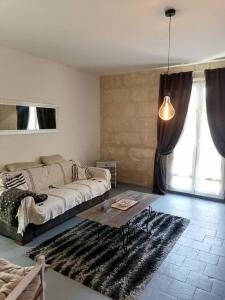 ein Wohnzimmer mit einem Sofa und einem Tisch in der Unterkunft Appartement rez de jardin in La Chartre-sur-le-Loir
