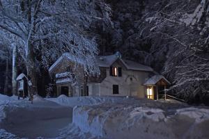 una casa con luci accese nella neve di notte di Chalet Il Cristallo-Monte Amiata a Castel del Piano