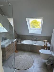 ein Badezimmer mit einer Badewanne, einem WC und einem Waschbecken in der Unterkunft Ferienwohnung gemütlich modern in Langenzenn