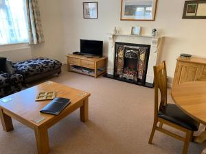 a living room with a coffee table and a fireplace at The Bothy in Lyndhurst