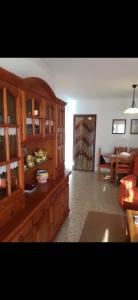 a kitchen with wooden cabinets and a living room at Beachfront 3 Bedroom Family Apartment in Matalascañas