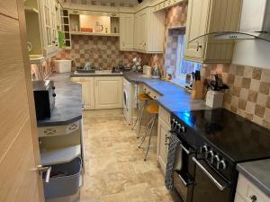 a kitchen with white cabinets and a black stove at The Bothy in Lyndhurst