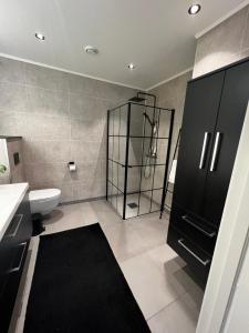 a bathroom with a shower and a sink and a toilet at Nytt hus i rolig familiestrøk in Verdal