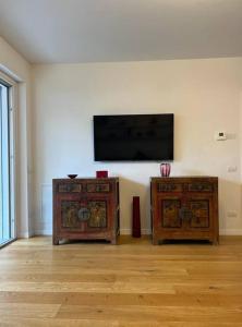 a room with two wooden cabinets and a flat screen tv at Casa degli Ori by the city in Prato