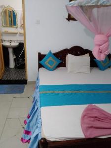 1 cama con sábanas azules y blancas y lavamanos en Rock Cascade tourist home en Polonnaruwa
