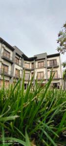 an apartment building with green grass in front of it at MAZZA Hotel in Tashkent
