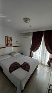 Un dormitorio con una cama con una pajarita. en Atalla Hotel, en Antalya