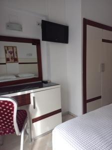 1 dormitorio con espejo, 1 cama y 1 silla en Atalla Hotel, en Antalya