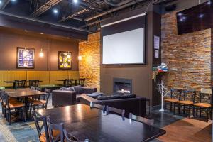 a restaurant with tables and chairs and a large screen at Quality Inn Winkler in Winkler