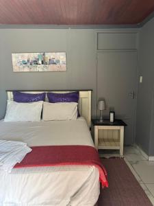 a bedroom with a large bed and a table at KKK Guesthouse in Secunda