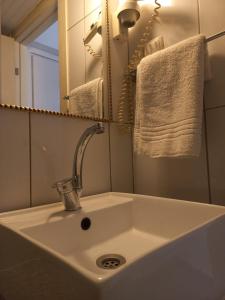umywalka w łazience z lustrem i ręcznikami w obiekcie Atalla Hotel w mieście Antalya